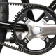 A close-up of the Detroit Bikes DB-E ebike in glossy black's belt drive and front cog.